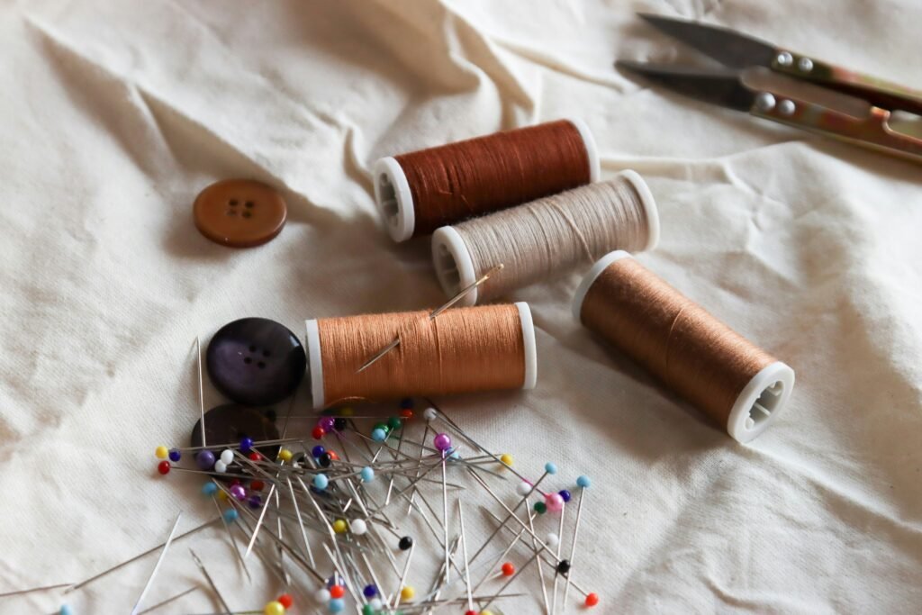 A basic sewing kit with buttons, a pair of scissors, pins, a needle and thread.